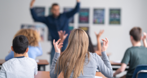 Actividades para realizar en tutoría. La Imagen muestra a varios alumnos de secundaria de espaldas subiendo las manos imitando a un profesor.
